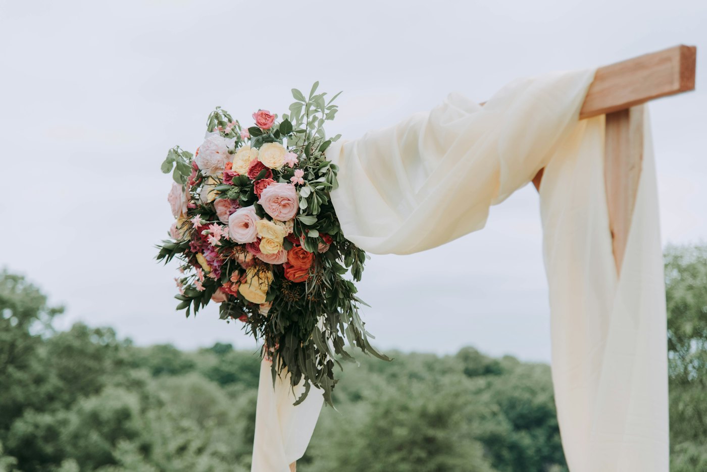 Blush and white floral swag on a draped arch