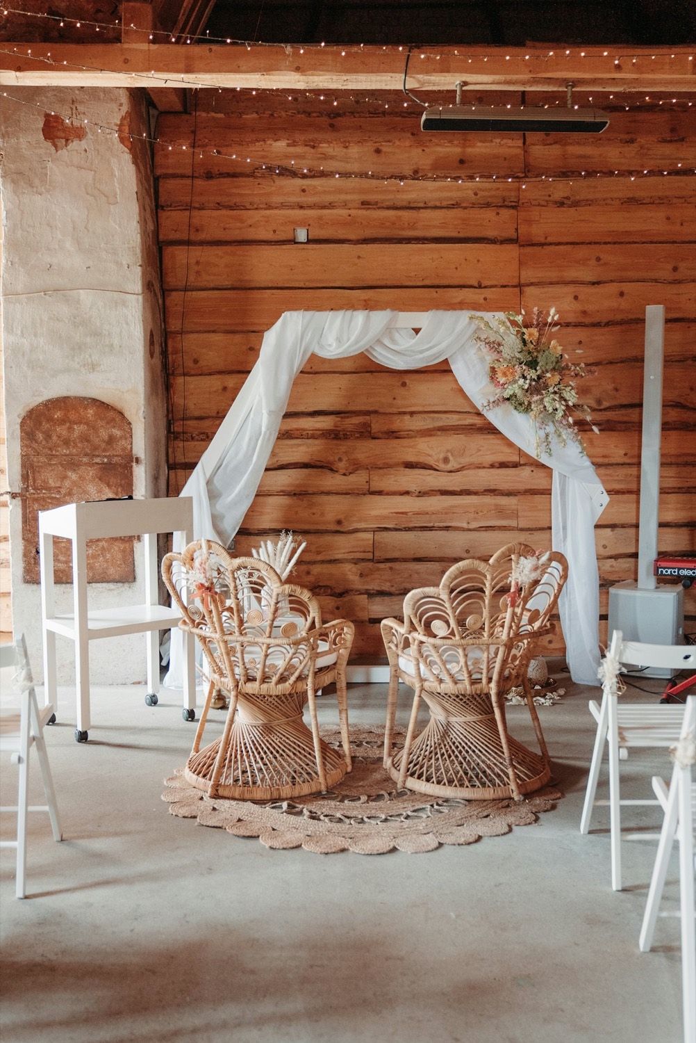 Draped fabric backdrop with rattan peacock chairs