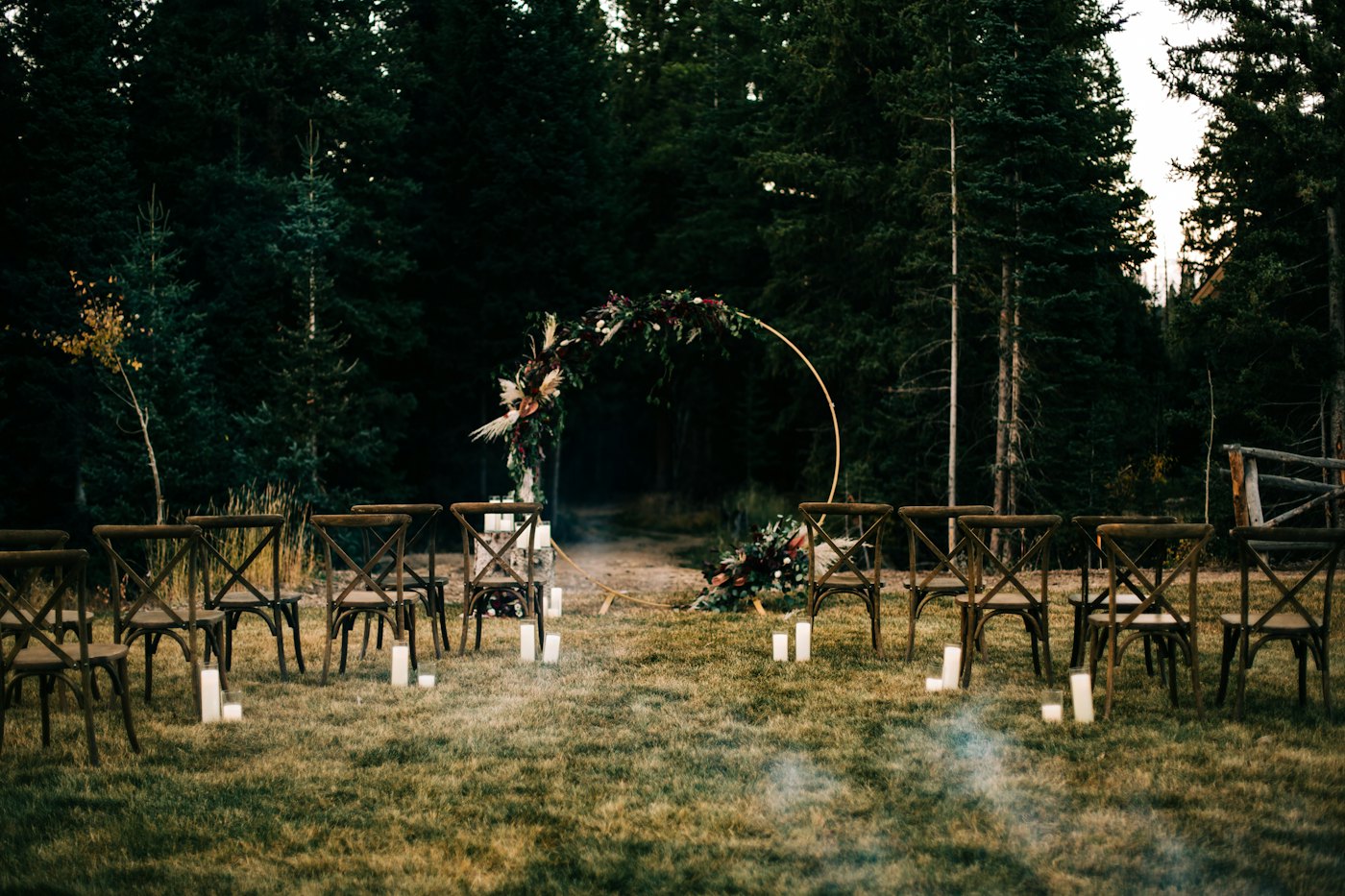 Round ceremony arch with florals set up in a pine forest