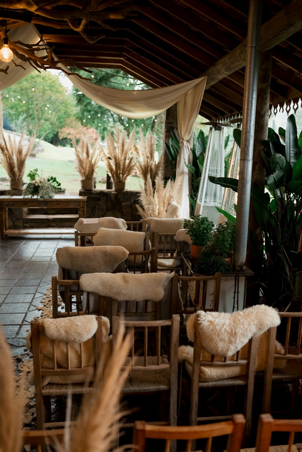 Seating with sheepskin throws beside pampas grass