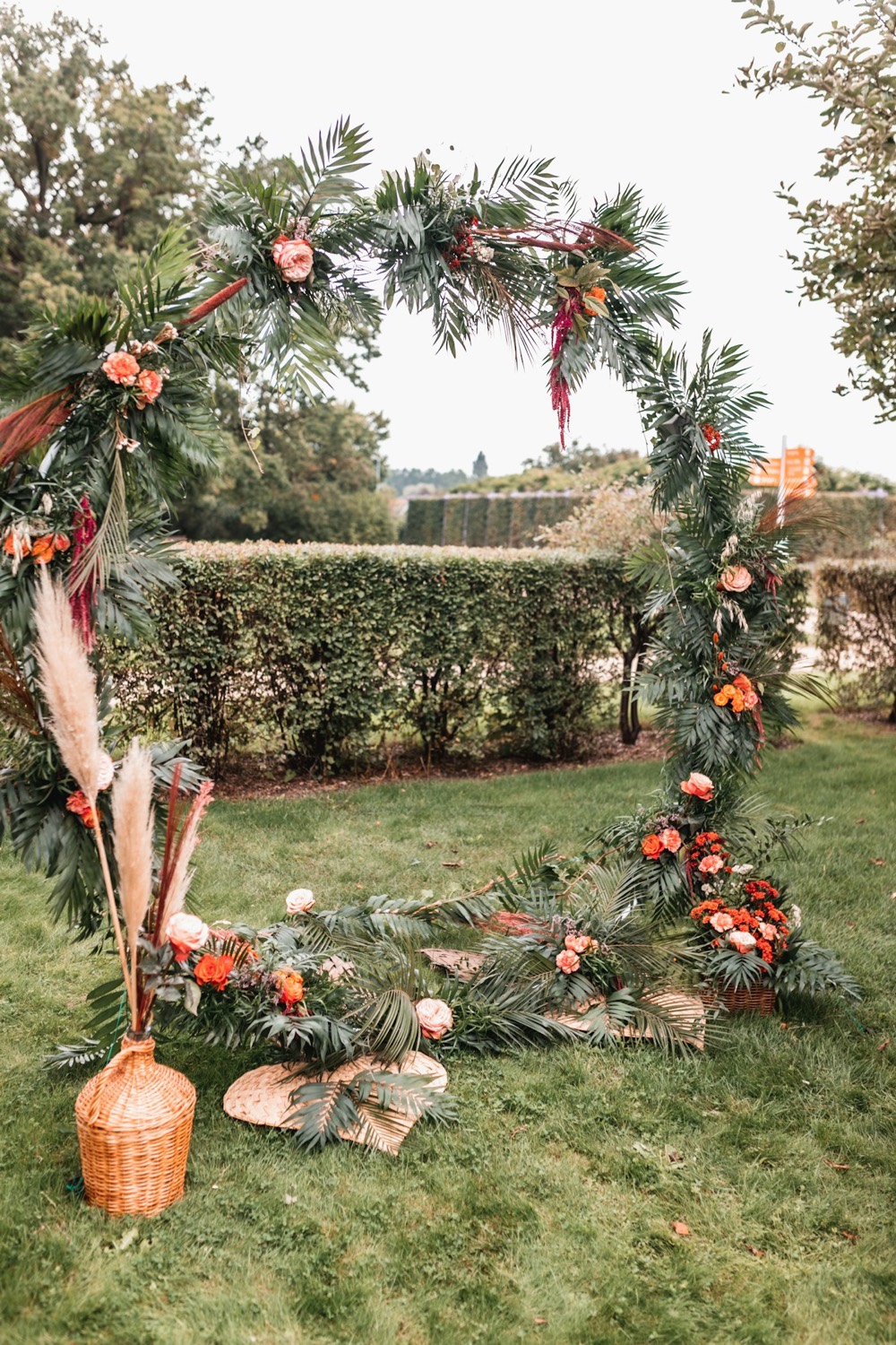 Round metal arch decorated with florals and pampas